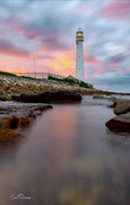 From the Rocks Slangkop – low angle view of Slangkop Lighthouse with silky water and pink sunrise sky