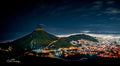 Lion's Head by night with Cape Town city lights glowing below and mist rolling in