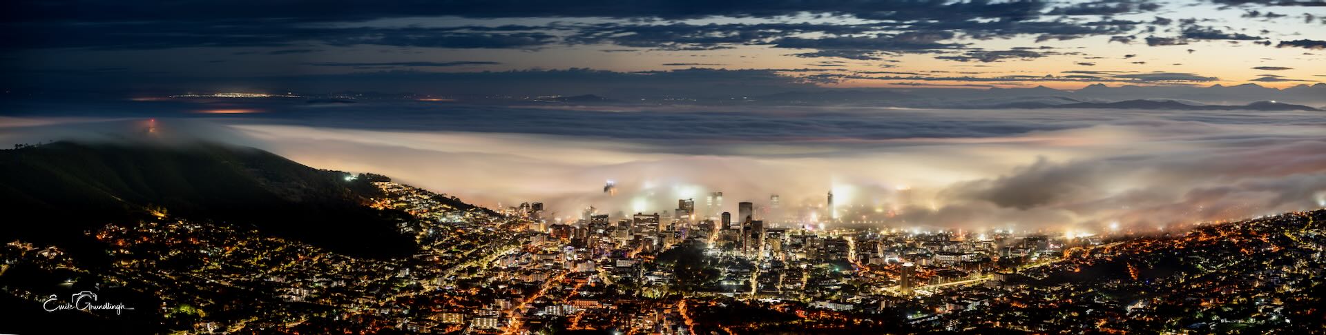 Cape Town CBD emerging through thick mist at night panorama