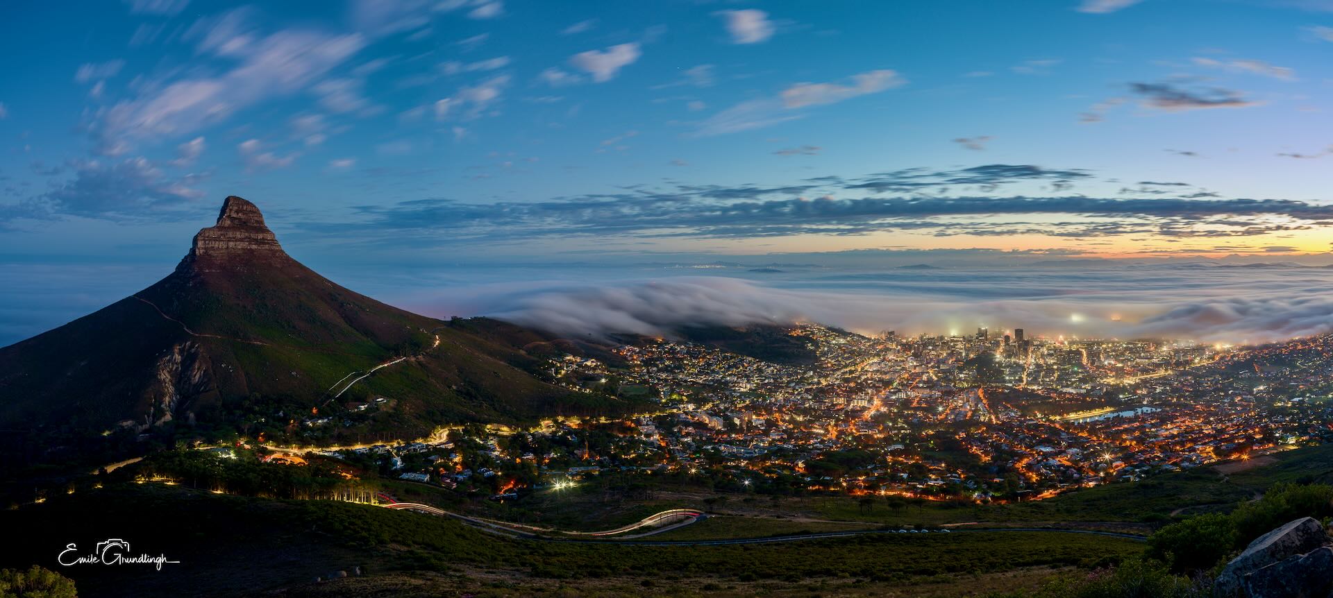 Lion's Head and Cape Town city lights at blue hour with mist rolling in