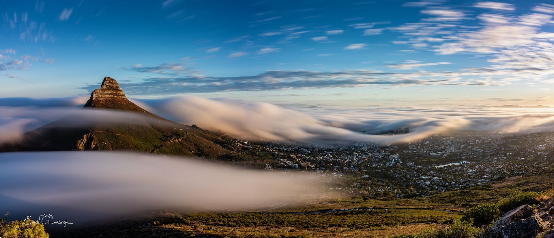Lion's Head rising above a river of clouds cascading over Cape Town