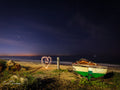 Light-painted heart glowing on Makriels Beach beside an old fishing boat under a starry False Bay night sky