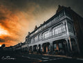 Victorian ironwork facade of Simon's Town Main Road against dramatic fiery storm sky, shot from street level