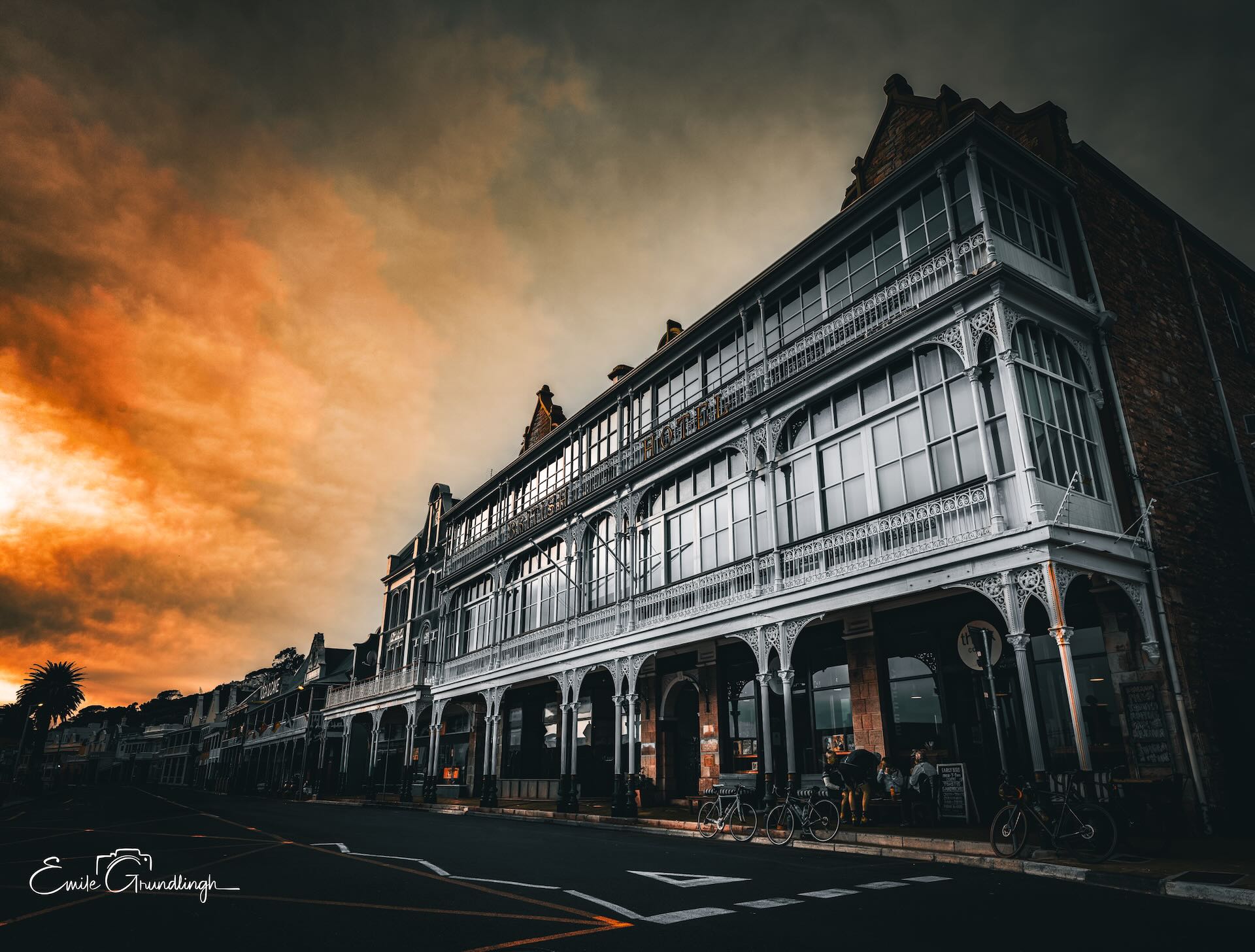 Victorian ironwork facade of Simon's Town Main Road against dramatic fiery storm sky, shot from street level