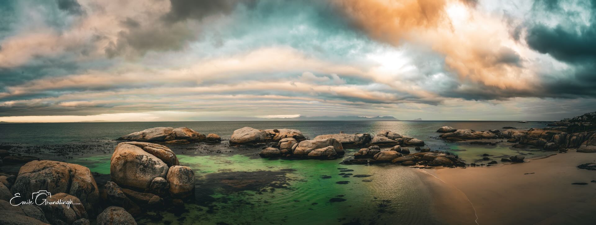 Windmill Beach panoramic view with dramatic storm clouds and emerald rock pools, Boulders Beach area