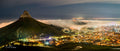 Lion's Head at night with mist rolling into Cape Town under starry sky panorama