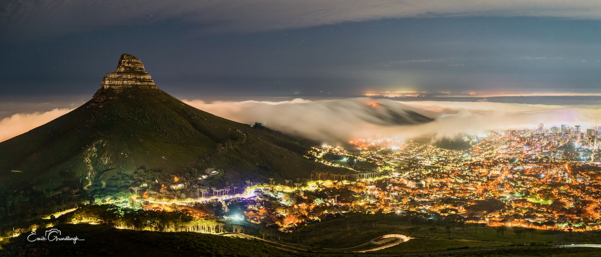 Lion's Head at night with mist rolling into Cape Town under starry sky panorama