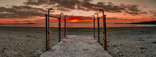 Beach showers framing a path to a fiery sunset at Clifton Beach Cape Town