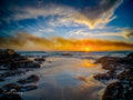 Fiery sunset over Noordhoek Long Beach with sea mist and tidal rock pools by Emile Grundlingh