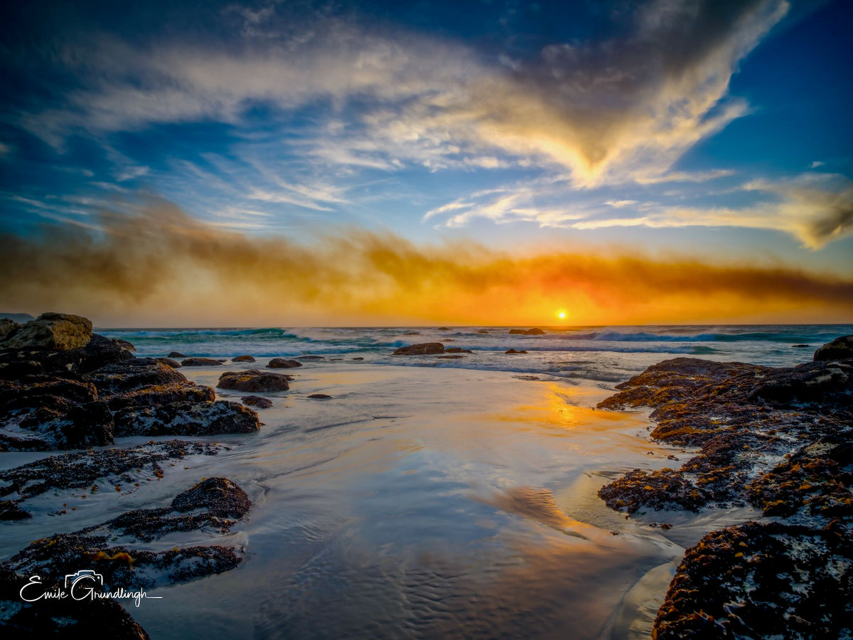 Fiery sunset over Noordhoek Long Beach with sea mist and tidal rock pools by Emile Grundlingh