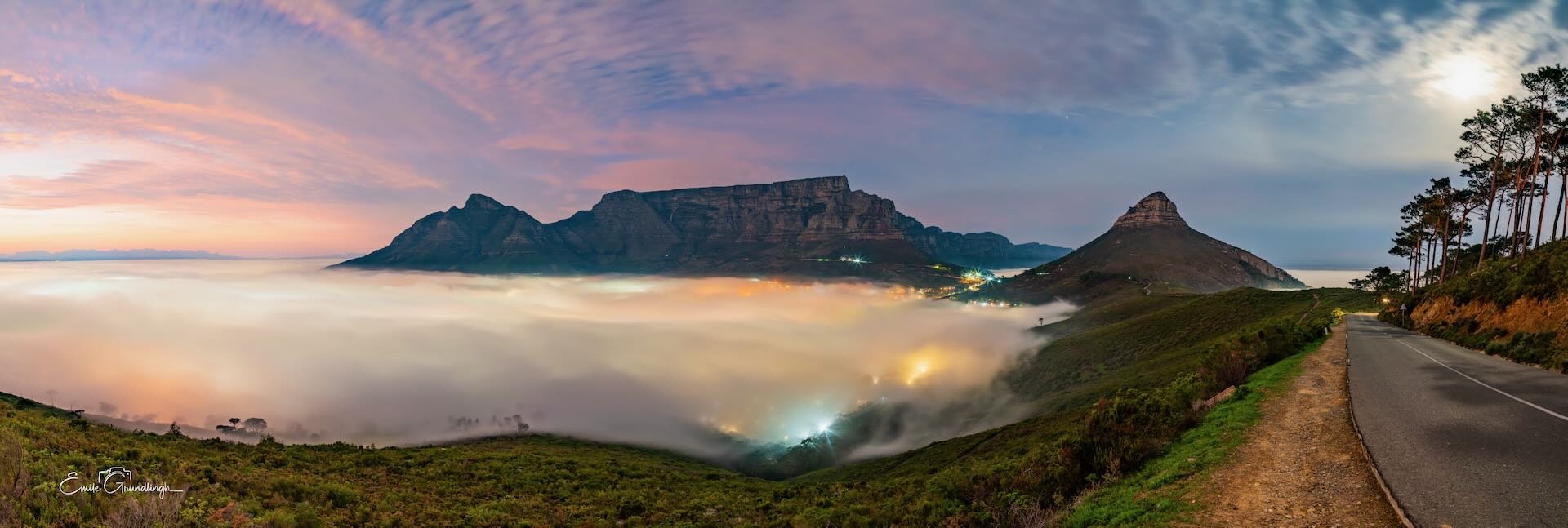 Table Mountain and Lion's Head rising above sea of mist at dawn from Signal Hill Road