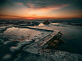 Wooleys Tidal Pool at sunset with silky water and fiery orange sky over False Bay
