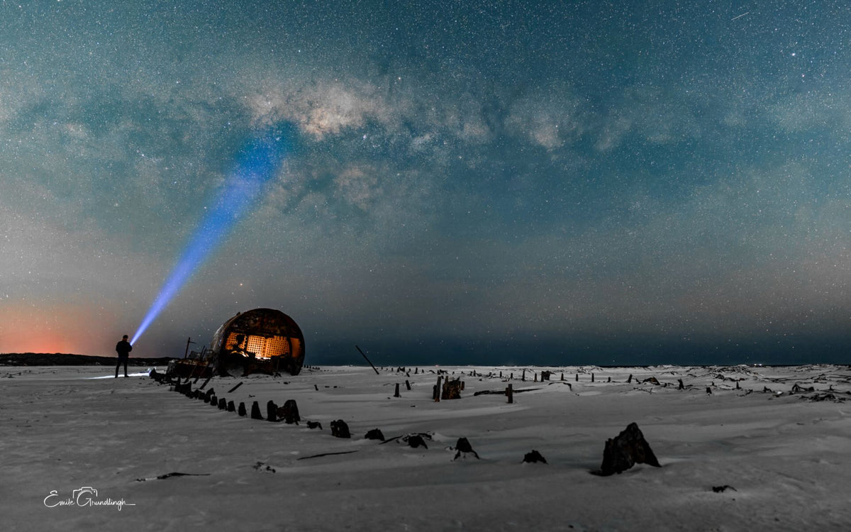 Lone figure with torch beside the Kakapo wreck under the Milky Way on Noordhoek Beach by Emile Grundlingh