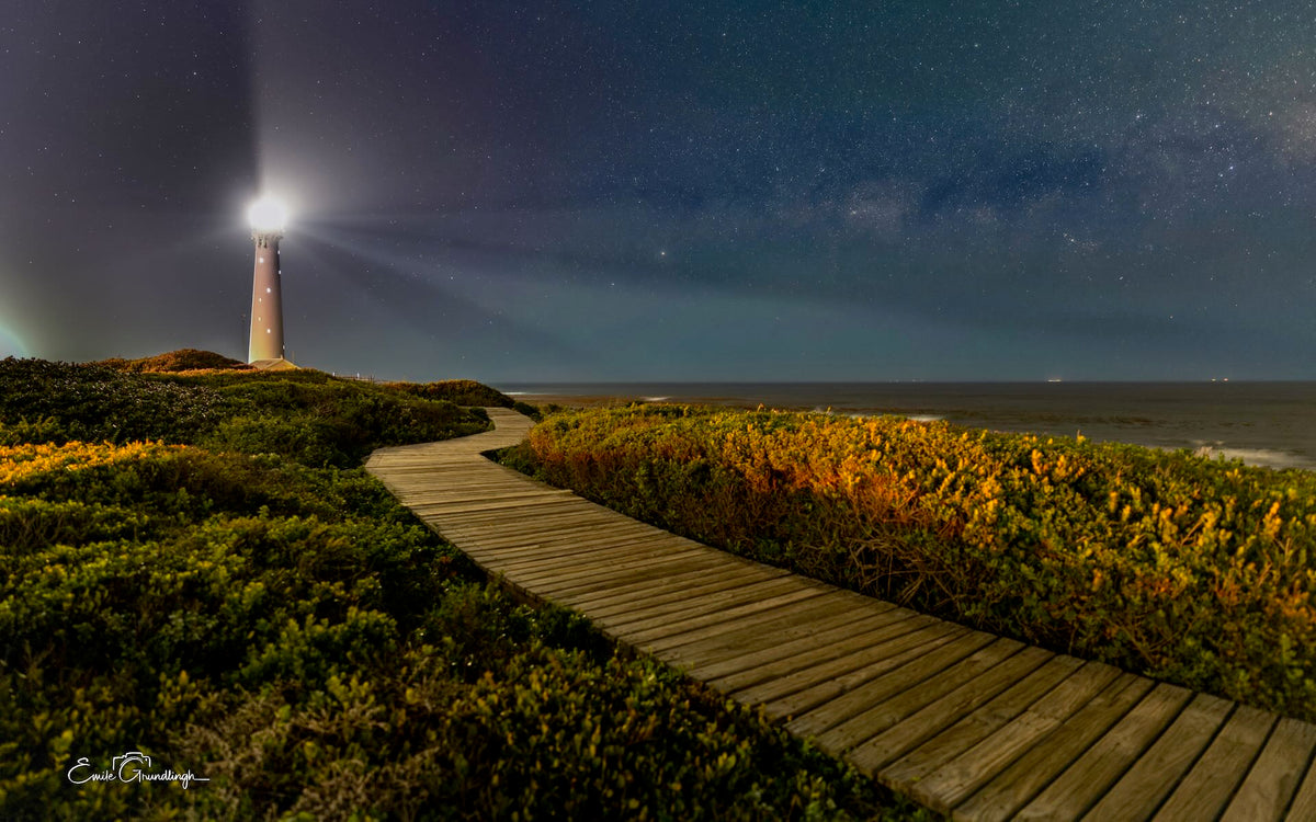 Slangkop After Dark – Slangkop Lighthouse beam at night with starry sky and boardwalk through fynbos