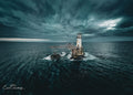 Aerial view of Roman Rock Lighthouse isolated in dark churning False Bay waters under dramatic swirling storm sky