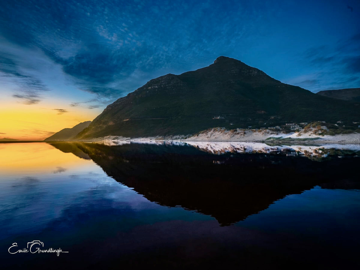 Noordhoek mountain reflected in a mirror-still tidal pool at dusk with golden sunset glow by Emile Grundlingh