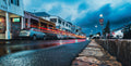 Kalk Bay main road at blue hour with vivid red and orange car light trails reflecting off wet tarmac under moody stormy sky