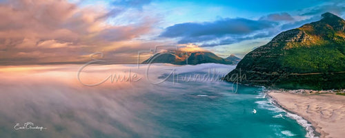 Aerial view of sea mist rolling over Noordhoek's Long Beach below Chapman's Peak Drive and its cliffs at sunrise