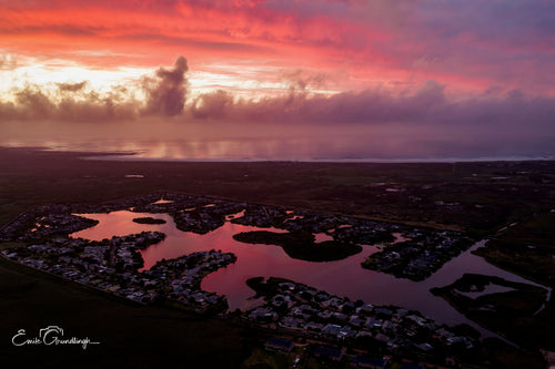 Aerial view of Lake Michelle canals reflecting crimson storm sunset by Emile Grundlingh