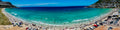 Aerial panorama of Fish Hoek Beach packed with swimmers and sunbathers on New Year's Day with vivid turquoise False Bay waters