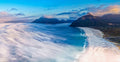 Aerial panorama of sea mist rolling across Noordhoek Long Beach with Hout Bay and mountains in morning light by Emile Grundlingh