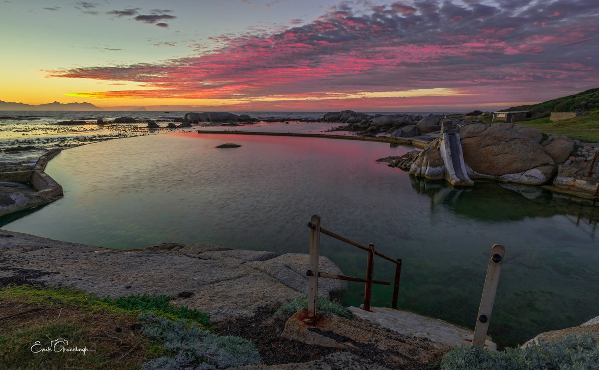 Daybreak at Millers Point tidal pool under a pink and red sky
